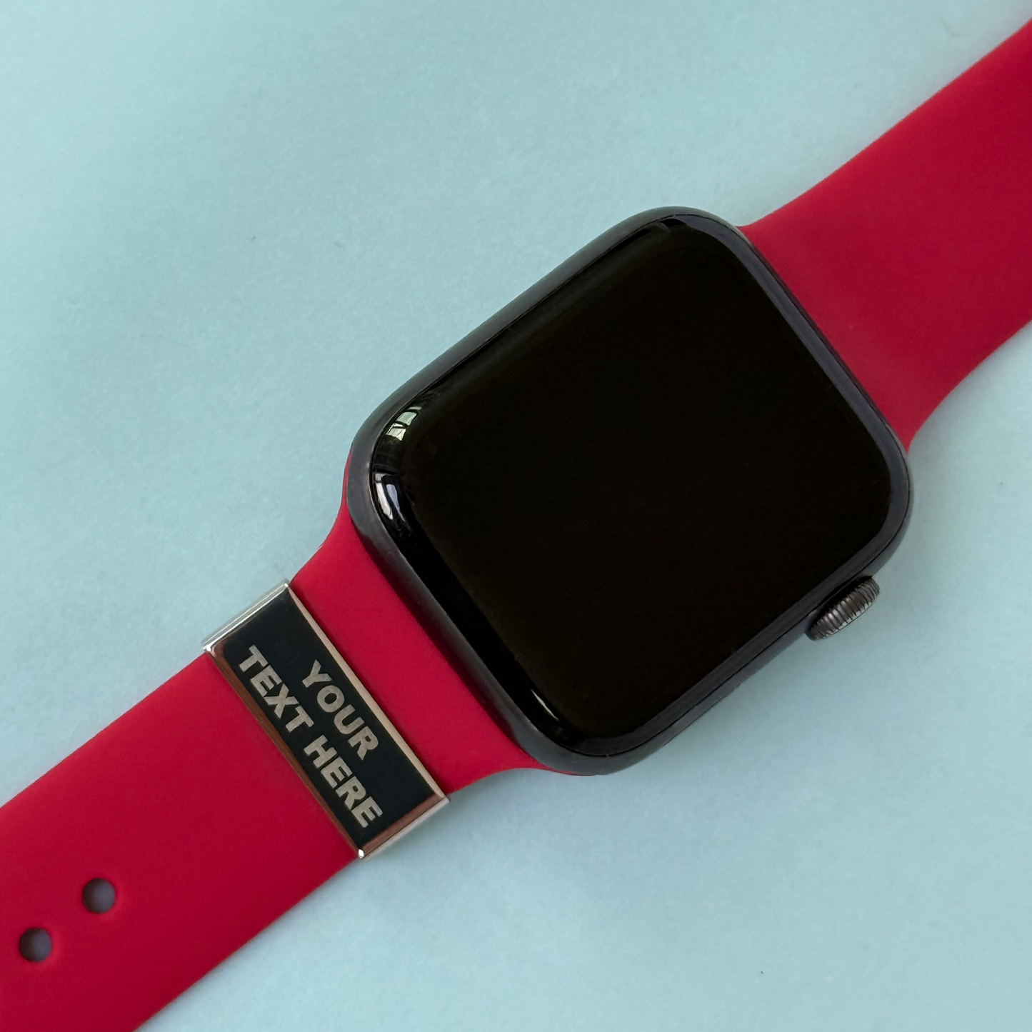 Customisable watch strap charm on red band engraved with 'Your Text Here' – personalised tag for Apple, Garmin and Whoop watches