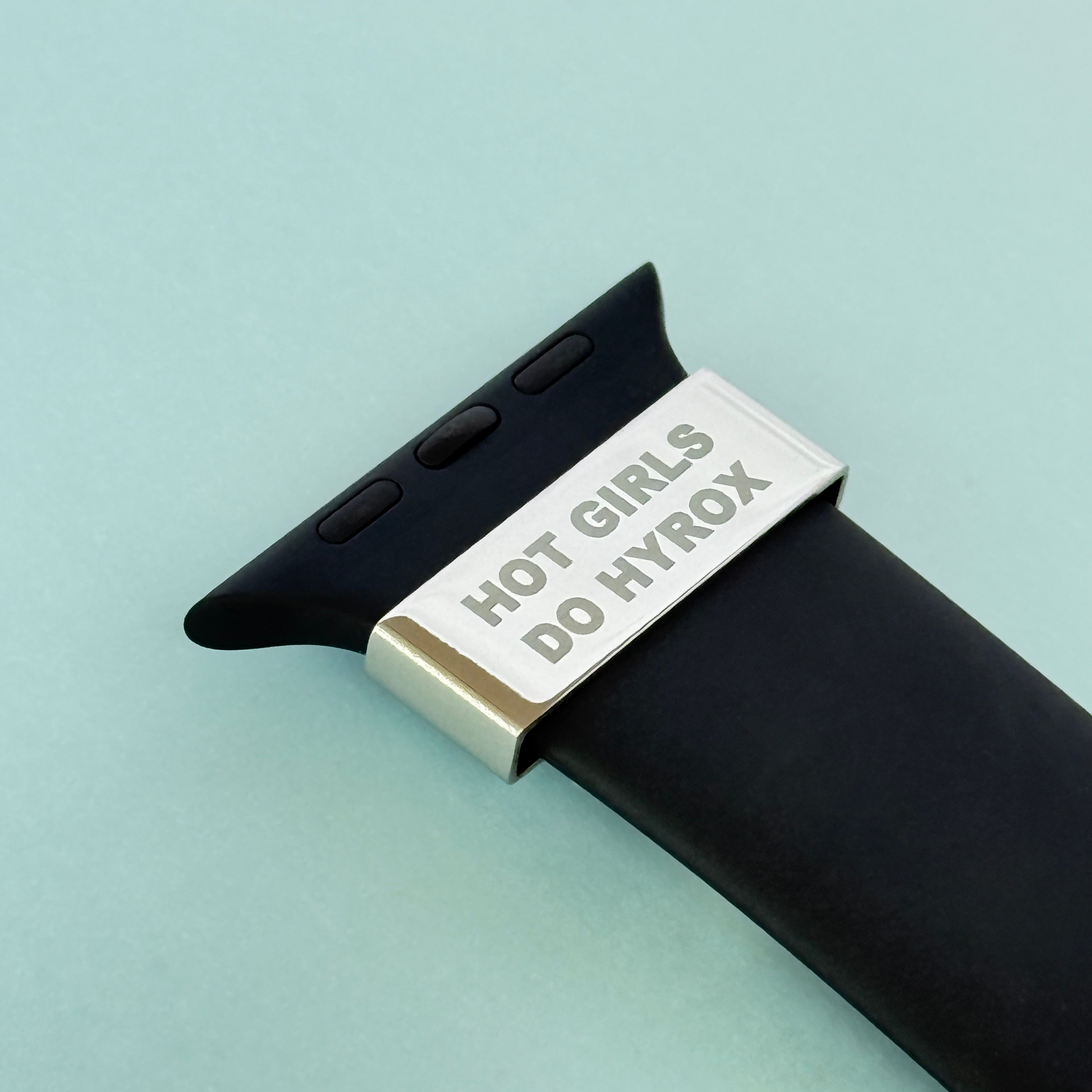 Close-up of motivational watch charm engraved with 'Hot Girls Do Hyrox' on black strap – fits Apple, Garmin and Whoop devices